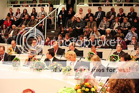 nieuwe raadsleden in de raadszaal met bloemen op tafel