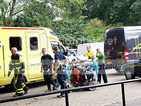 man op brancard naar ambulance